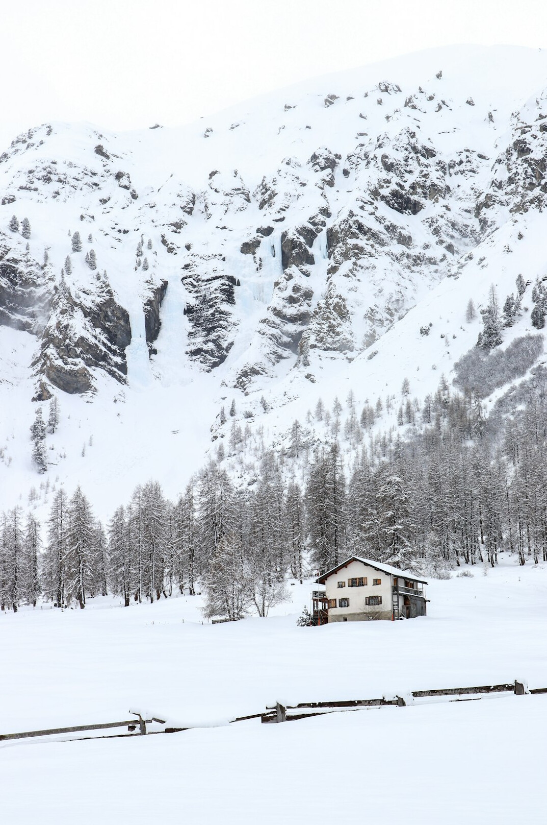 Wooden ski chalet in Graubünden covered in fresh snow